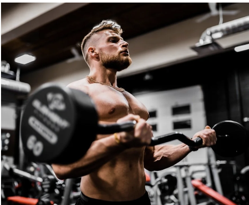 Athletic man lifting a barbell during a strength training session.